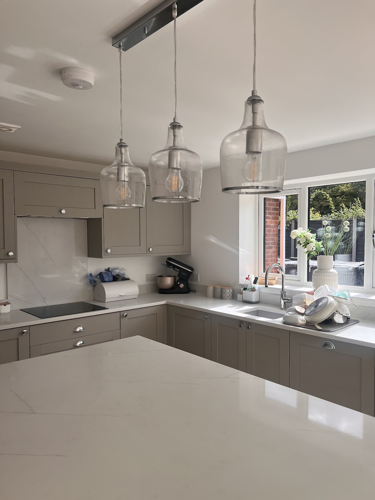 Bright cleaned kitchen with pendant lights and marble worktops